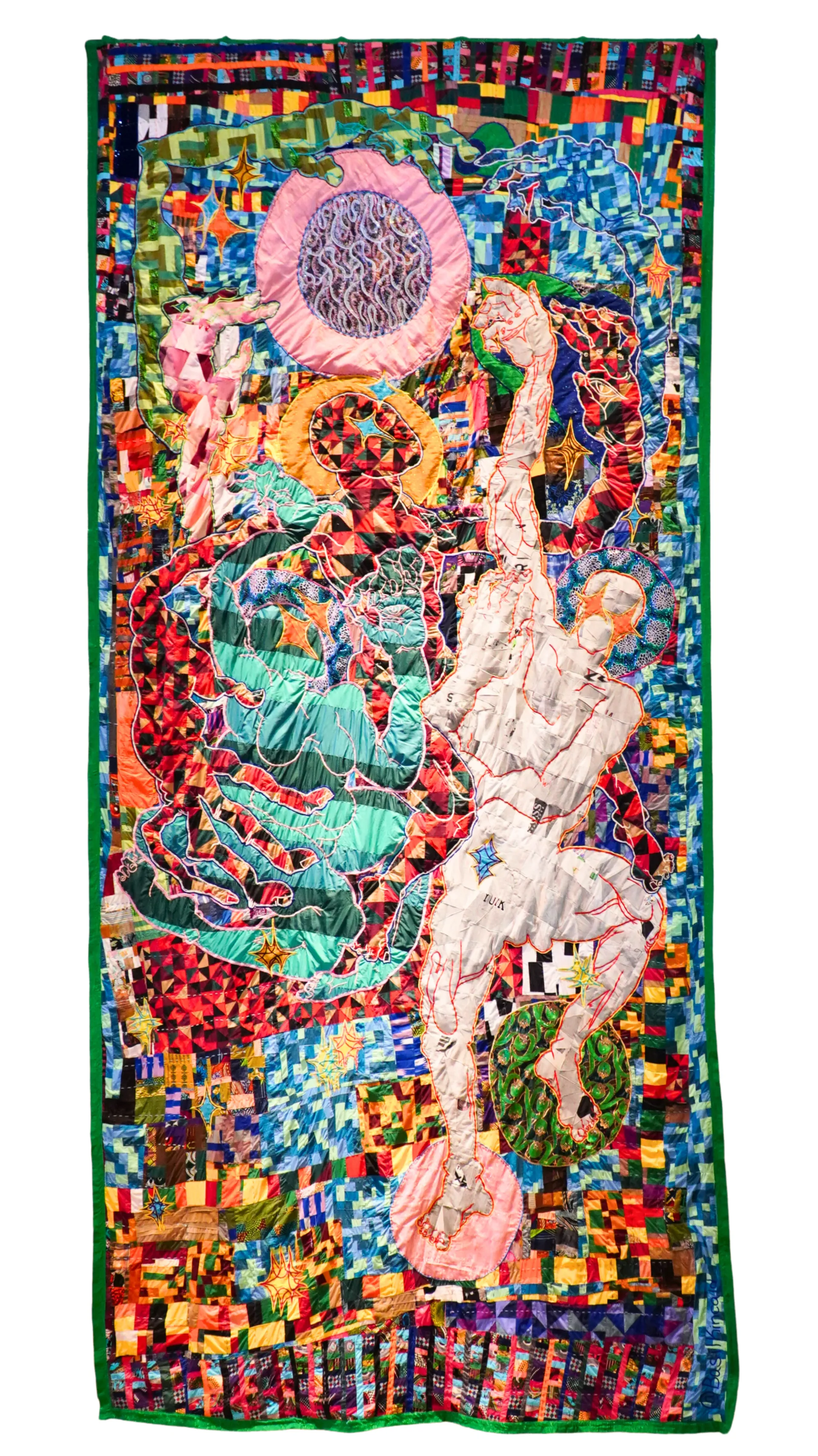 A photograph of a quilt with a person.