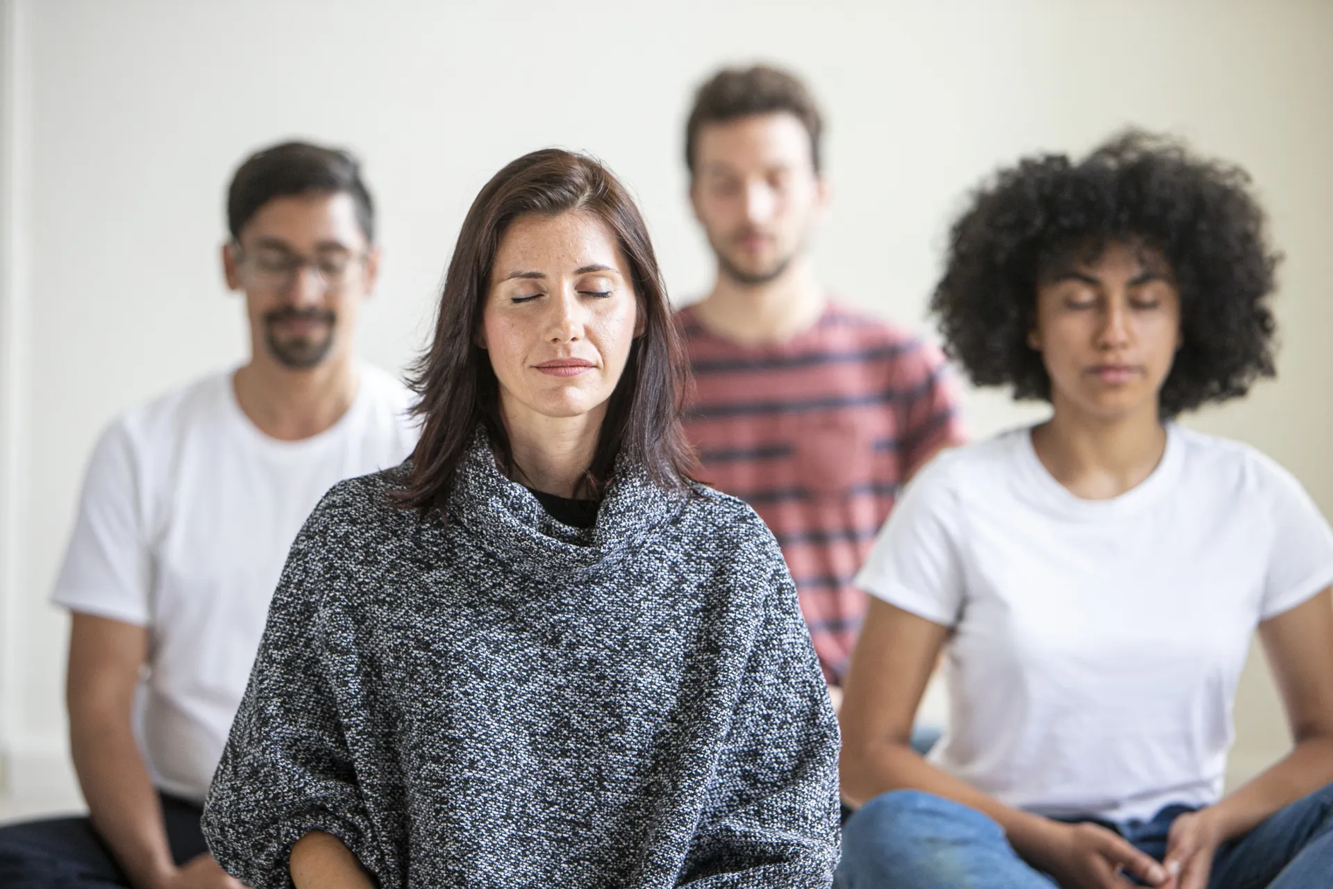 Individuals meditate together.