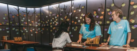 Facilitators for the Genealogy workshop guide a participant 